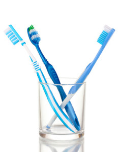 Toothbrushes in glass isolated on white